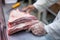 Selective focus shot of the butcher cutting a good piece of pork