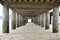 Selective focus shot of concrete pillars underneath a pier at the beach