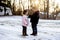 Selective focus shot of cute little kids reading the Bible in the middle of a winter park