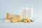 Selective focus shot of a delicious cheese platter with milk isolated on a light blue background