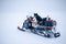 Selective focus shot of a dog sitting on a snowmobile in the north of Sweden