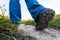 Selective focus shot of feet of a hiker in boots walking along a path on the outskirts of town