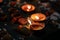 Selective focus shot flaming Diwali candles with flower petals on the sides