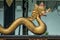 Selective focus shot of a golden snake statue with a blurred background