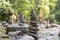 Selective focus shot of many stone pyramids balanced on a river water