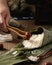 Selective focus shot of preparation of rice dumplings with banana leaves