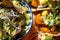 Selective focus shot of a salad with bread chips, greens, and a pesto sauce