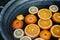 Selective focus shot of slices of orange floating in the water inside a vintage metal washtub