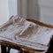 Selective focus shot of washed beige bed linen on the old wooden chair