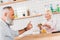 selective focus of smiling cafe worker offering pastry to senior man