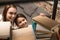 selective focus of smiling daughter taking book for reading from bookshelf