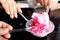 In selective focus some sweet shaved ice in a white plate with many hands of a women with small spoons