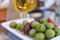 Selective focus on Spiced green split olives in a small plate the tapas bar table typical Spanish. In the background