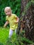 Selective focus on squirrel on a tree. Little toddler girl looks at a squirrel.