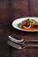 Selective focus stainless spoon and fork on wooden table