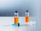 Selective focus. Syringe for injection and two ampoules of coronavirus vaccine and on a silvery aluminum background