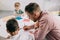 selective focus of teacher and multiracial boys drawing pictures with colorful pencils at table in classroom