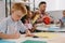 selective focus of teacher and multiracial preschoolers with colorful papers making paper applique