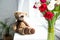 selective focus of teddy bear and bouquet of tulips in vase o window sill