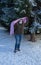 Selective focus of a teenage girl putting on a pink scarf to be supportive of breast cancer disease on a winter day that is