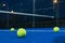Selective focus. Three paddle tennis balls on the surface of a blue paddle tennis court