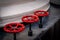 Selective focus on three red painted iron wheels on black ship deck. Industrial shipping objects.