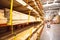 Selective focus timber shelves aisle with lumber cart, home improvement hardware store, chain link preventing warehouse rack