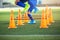 Selective focus to cone and hurdles marker with blurry kid soccer player Jogging and jump cross it.