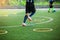 Selective focus to kid soccer player Jogging and jump at ring ladder marker on green artificial turf