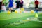 Selective focus to ladder drills on green artificial turf with blurry coach and kid soccer are training