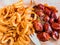 Selective focus. Traditional German currywurst, served with chips on a plate