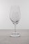 Selective focus of transparent wine glasses on tablecloth isolated on grey