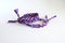Selective focus of two purple woven DIY friendship bracelets handmade of embroidery bright thread with knots on white background
