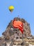 Selective focus of Uchisar castle, one of the most famous landmark in Turkey with Turkish flag and one hot air balloon just over