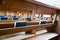 Selective focus view of many wooden church pews with blue bibles