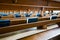 Selective focus view of many wooden church pews with blue bibles