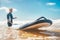 Selective focus with wide open aperture of long surf board on ocean waves with unfocused Young Man surfer on the background.