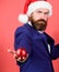 Selective focus. winter season fun. merry christmas. bearded man santa hat hold red xmas ball. be creative. event