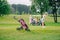 selective focus of woman with golf club playing golf and friends resting at golf cart