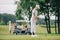 selective focus of woman with golf club playing golf and friends resting at golf cart