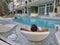 selective focus of woman relaxing in a chair in swimming pool