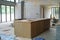 Selective focus on wooden kitchen island under installation in the house under construction