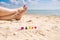 Selective focus on the word Happy on the background of female feet and the sea.
