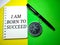 Selective focus.Word I AM BORN TO SUCCEED on a notebook with pen and compass on a yellow and green background.Motivation concept.