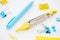 Selective focus of yellow and blue stationery with paper clips, compasses, pencil sharpener and pen on white background.