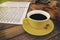 In selective focus of yellow ceramic coffee cup put beside violin ,in wooden timber board
