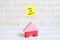 Selective focus of yellow sticky notes written with BUY OR RENT? with house toys on white wooden background. Real estate theme