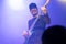 Selective focus on young Asian man bassist`s right hand performing playing electric bass solo on stage at concert