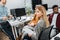 Selective focus of young businesswoman with papers near multiracial colleagues at workplace