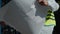 Selective focus of young caucasian civil engineer wearing safety helmet and vest standing at construction site